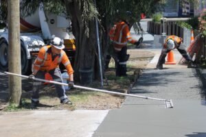 Team of concrete contractors in Idaho Falls finishing a sidewalk installation with precision.